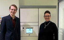 Webbild - Rektoratsdirektor Stefan Gumpelmeier und Claudia Peter bei der Eröffnung der neuen Bücherabholstation 